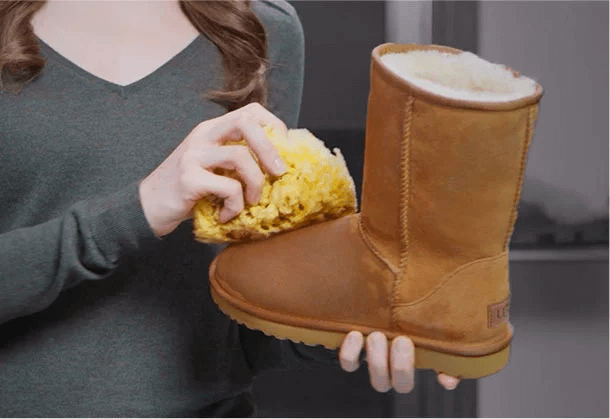 Woman damping Ugg classic with a sponge