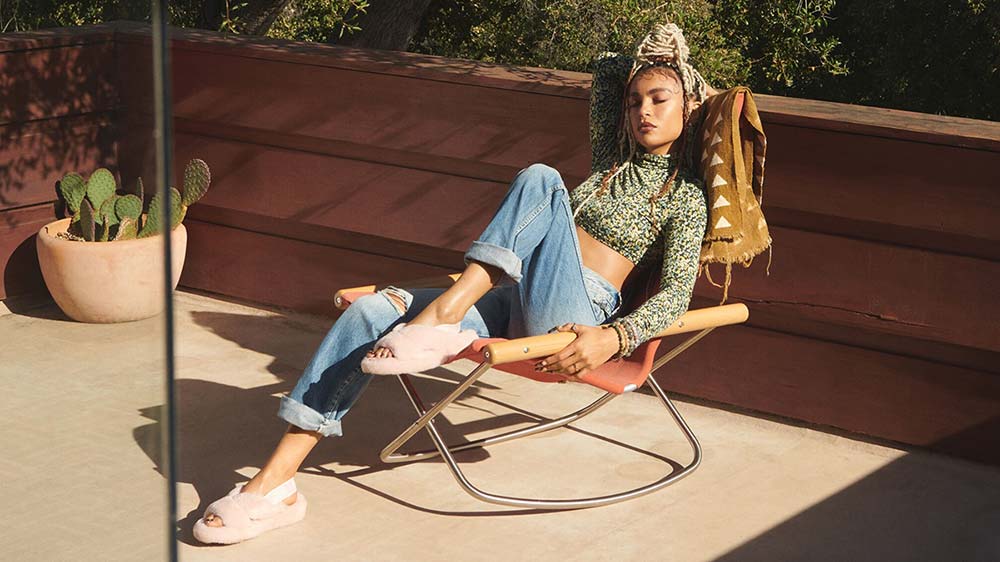 Woman in UGG sandals lounging in a chair.