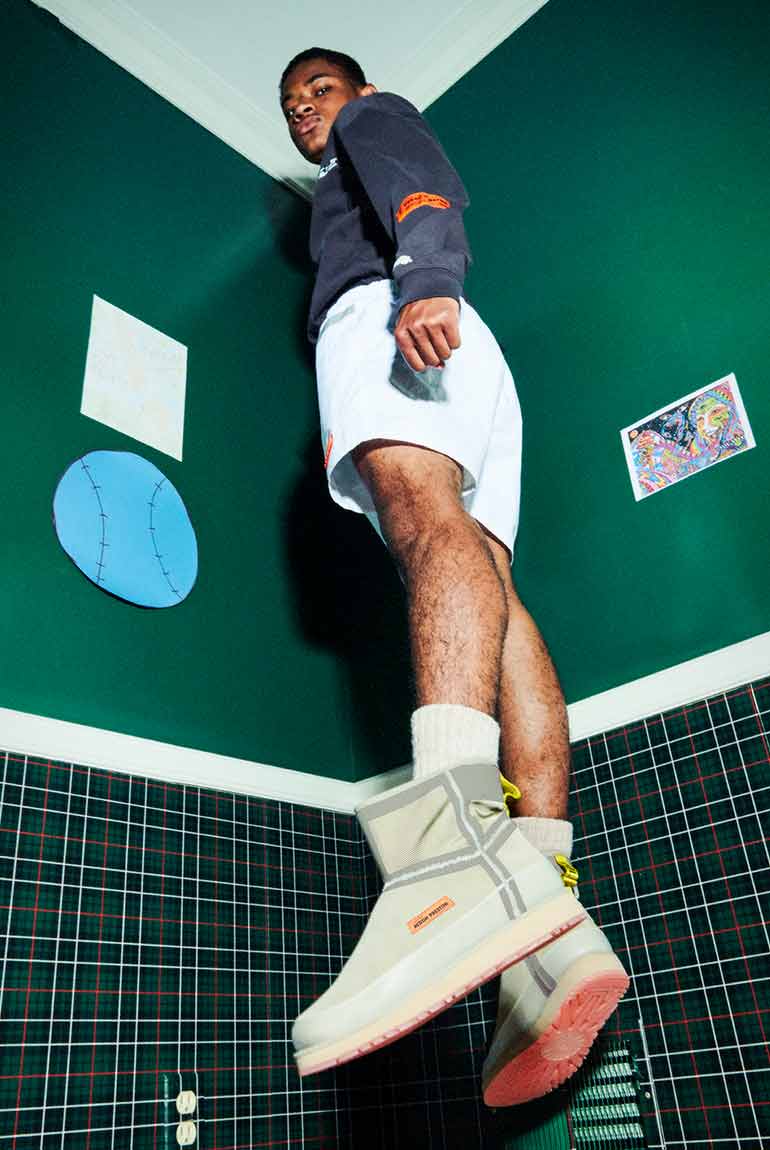 Boy jumping in air wearing the UGG X HP Clsasic Short Zip Waterproof.
