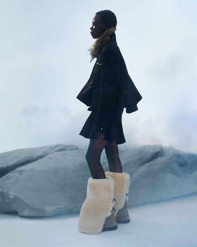 A feminine person wearing the new UGG sacai collaboration boots, paired with a smart fit and artfully touseled hair.