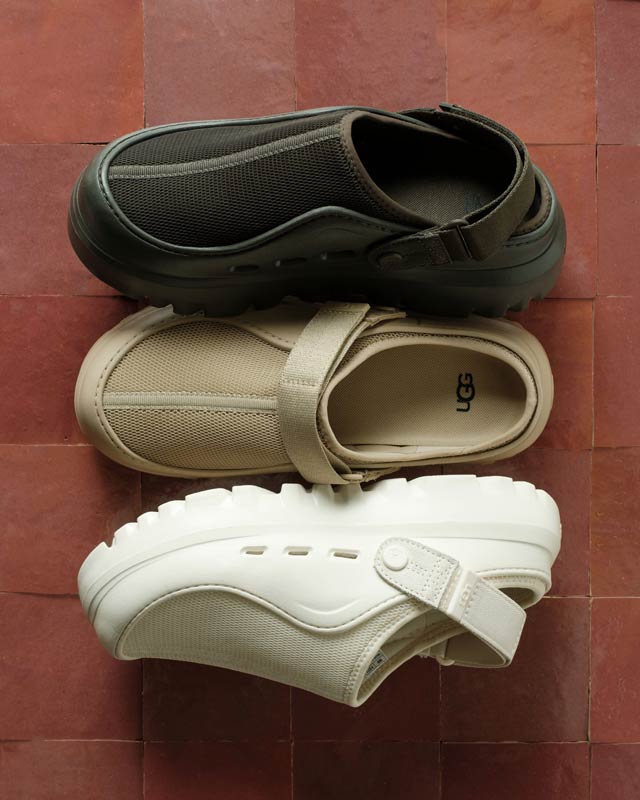 A detail shot of the UGG PeakMod shoe in a variety of different colors, all set on a rich, terracotta tile backdrop.