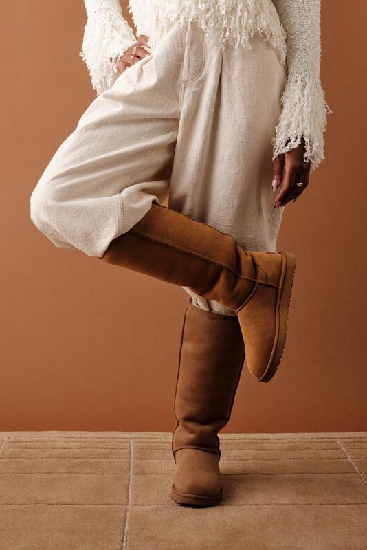 A shot of the UGG Classic Ultra Tall Boots modeled by someone wearing a matching fit in neutral colors.