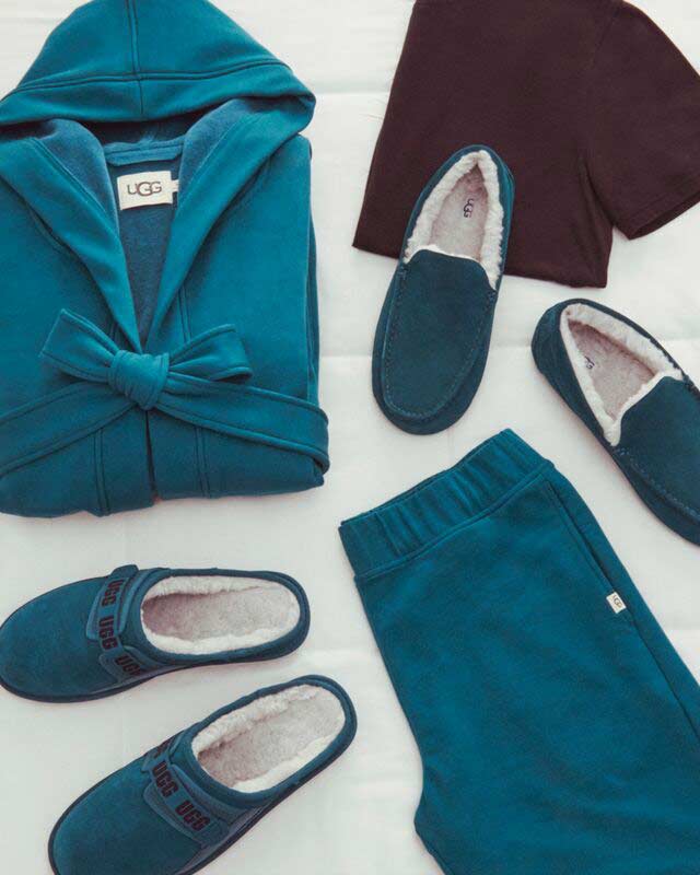 A detail shot of masculine UGG loungewear and slippers on a white background.