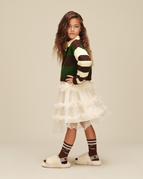 A kid wearing the returned kids Fluff Yeah shoes paired with a floofy and complimentary fit.